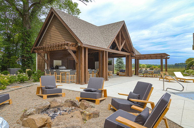 outdoor fire pit area with timber frame pavilion in background